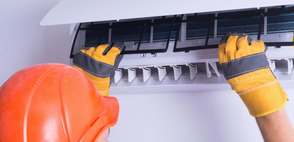 technician replacing filters in ac unit