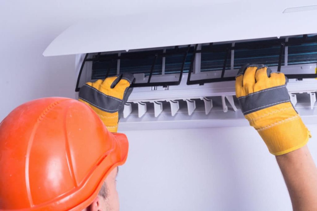 man installing filters in ac