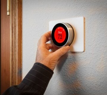 Hand adjusting a digital thermostat