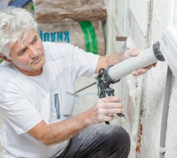 Man sealing window