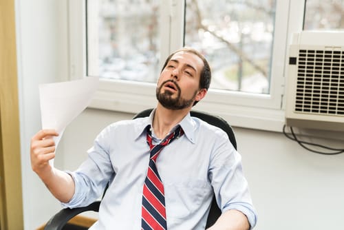 man sitting next to indoor ac unit