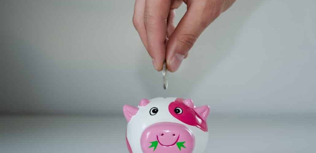 inserting money is small piggy bank