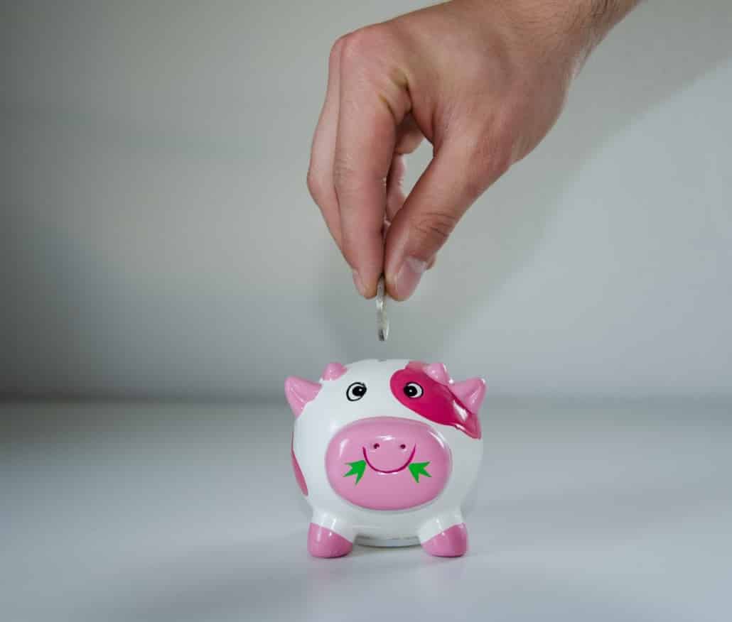 inserting money is small piggy bank