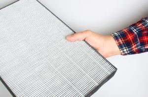 man holding air filter in hand