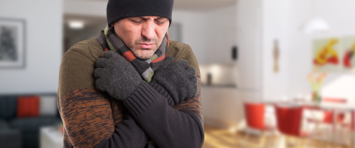 man shivering inside of cold house