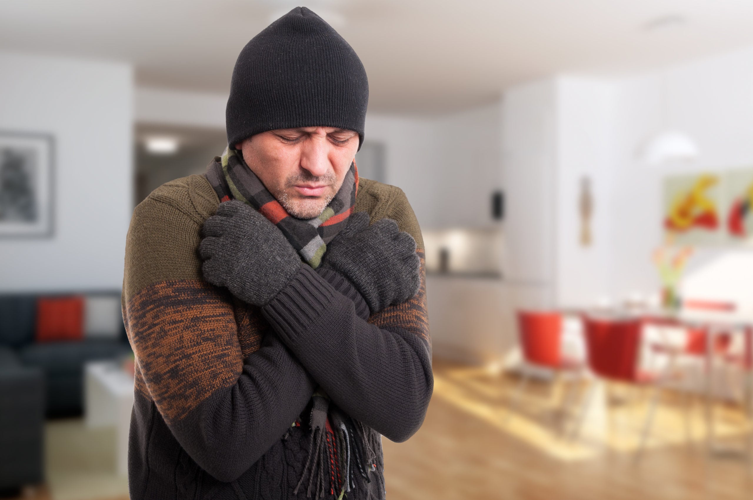 man shivering inside of cold house